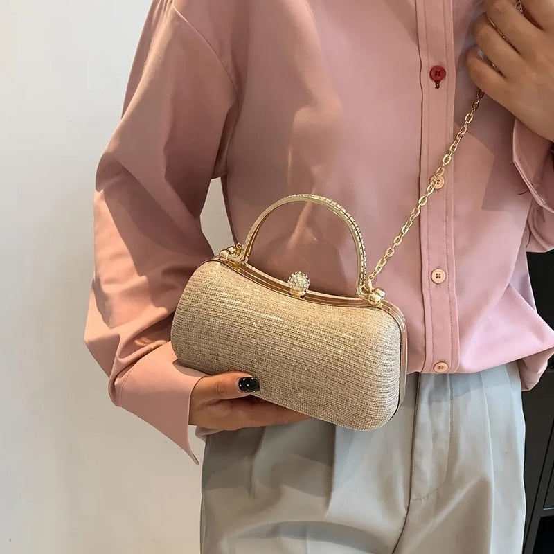 Bolsa feminina de festa ELIORA com acabamento em glitter e strass, alça de ombro fixa e fecho metálico de pressão.